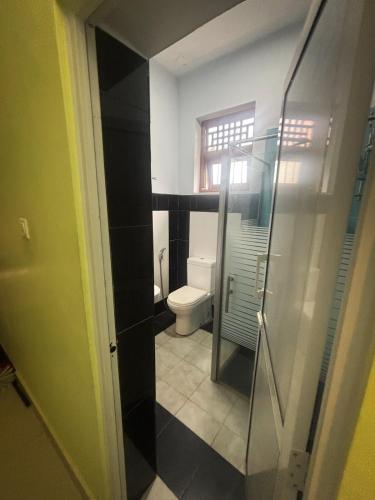 a bathroom with a toilet and a glass shower at Tea Estate Villa in Ratnapura