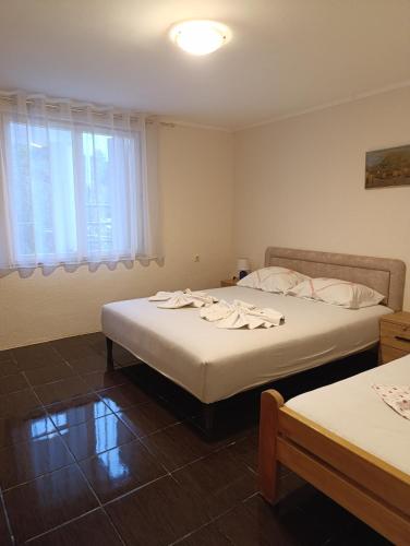 a bedroom with two beds and a window at Apartments Nenadić in Utjeha