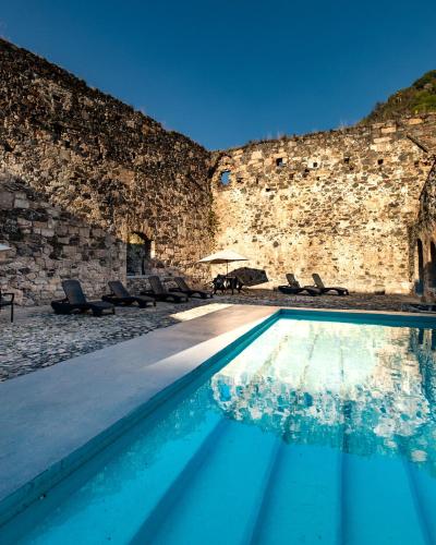 a swimming pool in front of a stone wall at Hacienda Santa Maria Regla in Huasca de Ocampo