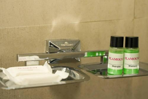 two bottles of shampoo on a shelf in a bathroom at Hotel Flamount Hitech City in Hyderabad