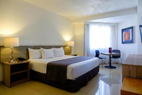 a hotel room with a bed and a window at Hotel Laffayette Ejecutivo in Guadalajara