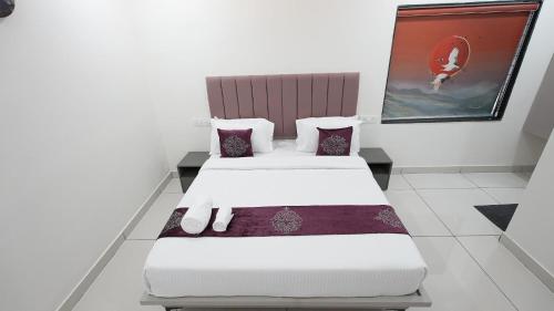 two beds in a room with a painting on the wall at Hotel Flamount Hitech City in Hyderabad