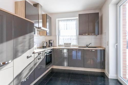 a kitchen with stainless steel appliances and a window at Villa Strandoase in Wohlenberg