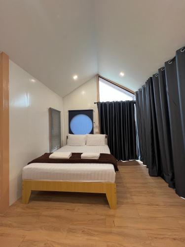 ein Schlafzimmer mit einem großen Bett und schwarzen Vorhängen in der Unterkunft JAYLA Resort in Sattahip