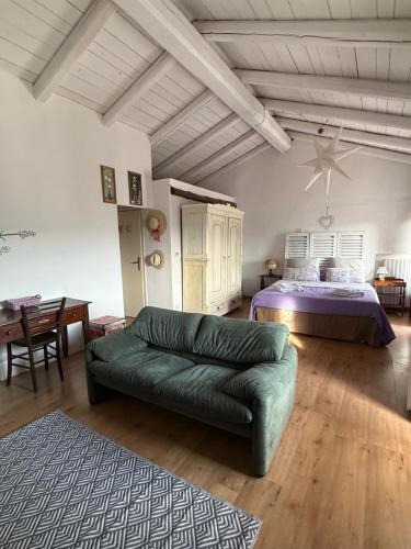 ein Wohnzimmer mit einem Bett und einem grünen Sofa in der Unterkunft View & Wine Room in Canelli