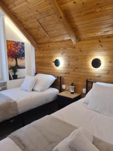 two beds in a room with wooden walls at TARNO Lake Apartment in Tarnobrzeg