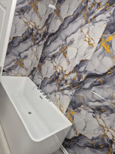 a bathroom with a marble wall at Căsuțele Ritei in Săpânța