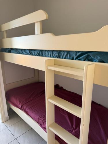 a bunk bed with purple and white bunk beds at Studio Horizon in Palavas-les-Flots