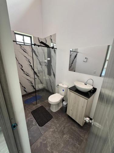 a bathroom with a toilet and a sink at Villa Alma in Medellín