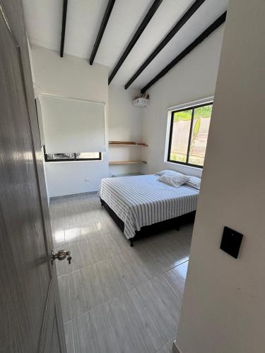 a bedroom with a bed and a window in it at Villa Alma in Medellín