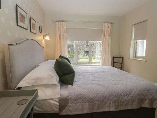 a bedroom with a bed and a window at Gable End in High Yewdale