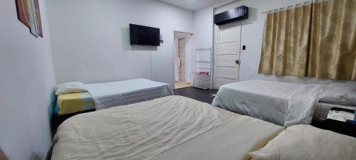 a hospital room with two beds and a television at Apto cerca a Paseo Colon in Puerto La Cruz