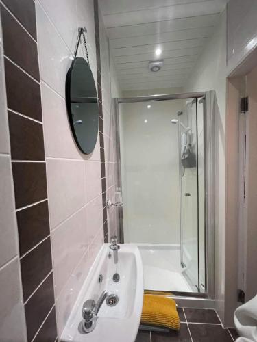 a bathroom with a tub and a sink and a mirror at Kirkhill Cottage B&B in Crossmichael