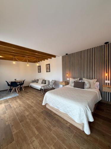 a bedroom with a large white bed and a table at La casuca de Candela in Santillana del Mar