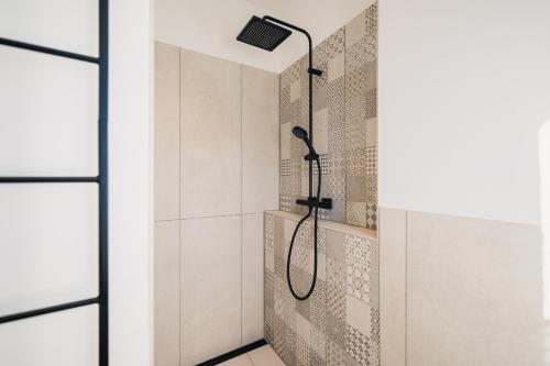 a shower with a shower head in a bathroom at Strandgeflüster deluxe in Zingst