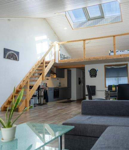a living room with a wooden staircase and a living room at Muota River Loft & Muota Industry Apartment near Stoos in Muotathal