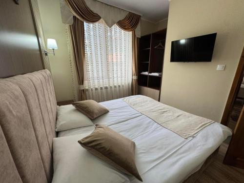a hotel room with a bed and a television at Ивелия Къща за гости in Dospat