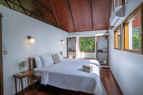a bedroom with a white bed and a window at Casa Leon in Talamanca