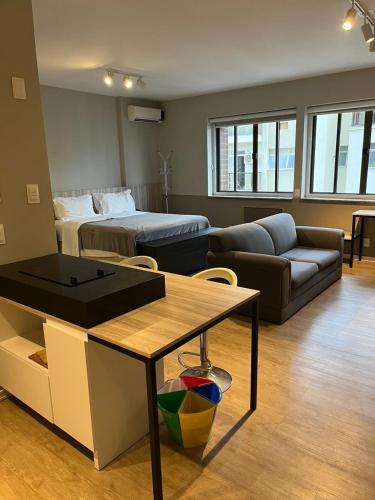 a living room with a bed and a couch at Flat no coração de Joinville in Joinville