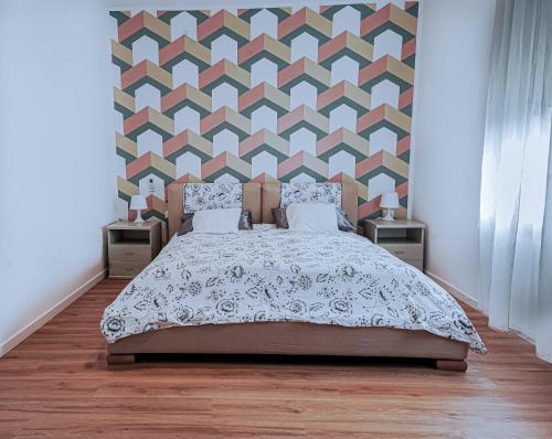 a bedroom with a bed and a geometric wall at The Ngatchou in Mestre