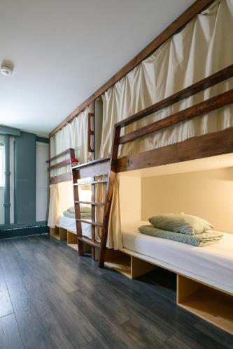 two bunk beds in a room with wooden floors at The Haven Hostel in Thunder Bay