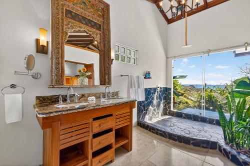 a bathroom with a sink and a shower with a window at Ocio Villas Mal Pais in Santa Teresa Beach