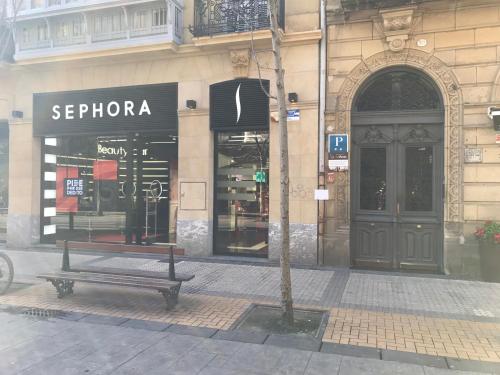 a building with a bench in front of a store at Pensión La Perla in Donostia-San Sebastián