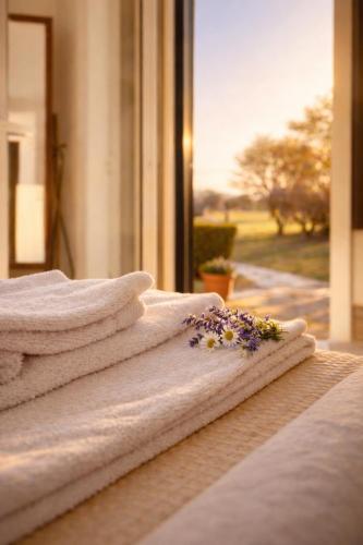 a pile of towels sitting on a bed with a window at Agriturismo Il Querciolo in Grosseto