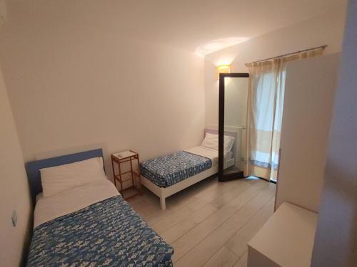 a small room with two beds and a mirror at Casa Dessi in Tanaunella