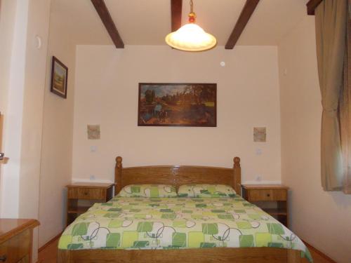 a bedroom with a bed and a painting on the wall at Kuća za odmor "Karalic" in Ležimir
