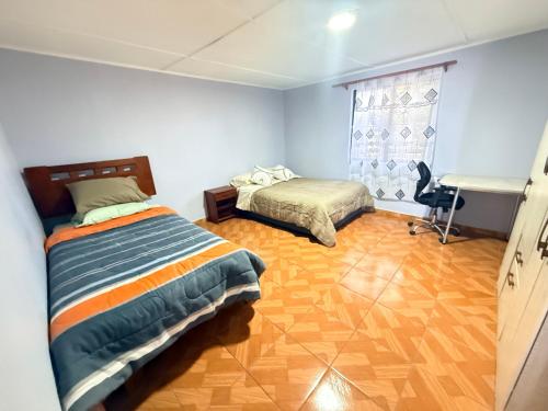a bedroom with two beds and a desk in it at Oasis terrenal Toconao in Toconao