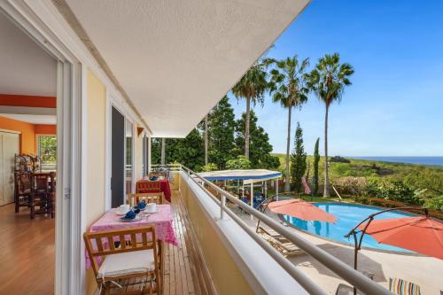 a balcony with a view of a pool and palm trees at Luana Inn in Captain Cook