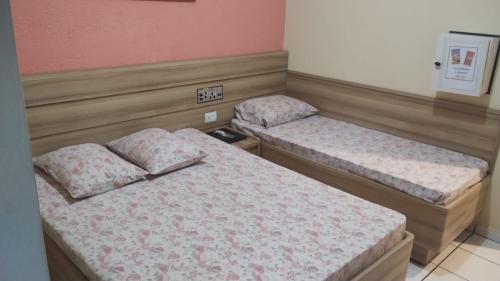 two twin beds in a room with pink walls at Hotel Styllus in São Paulo