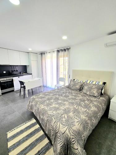 a bedroom with a bed and a kitchen and a table at Casa Vinhas - O teu refúgio no coração da cidade in Macedo de Cavaleiros