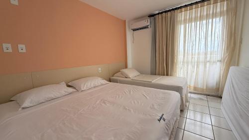 a small bedroom with two beds and a window at Gran Lençóis Flat - Barreirinhas -MA in Barreirinhas