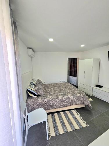 a bedroom with a bed and a chair in it at Casa Vinhas - O teu refúgio no coração da cidade in Macedo de Cavaleiros