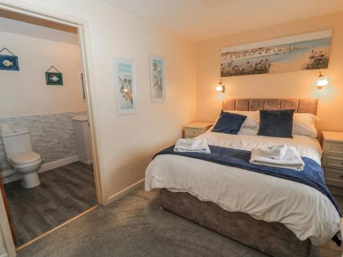 a bedroom with a bed and a bathroom with a toilet at Carthouse in Weston-super-Mare