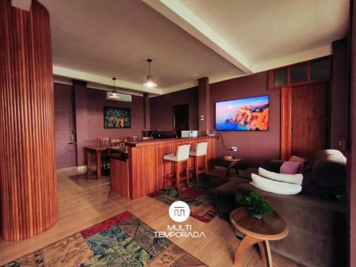 a living room with a tv on a wall at Casa na Lagoa - Imaruí/SC in Imaruí