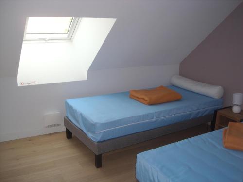 a attic room with two beds and a window at ESCALE MORVANDELLE studio 2 personnes in Saint-Brisson