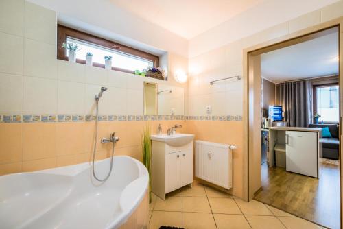 a bathroom with a tub and a sink at Apartman Elegance in Liptovský Mikuláš