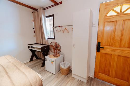 a bedroom with a bed and a desk with a fan at Chill Atacama in San Pedro de Atacama