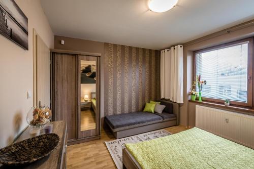 a living room with a couch and a window at Apartman Elegance in Liptovský Mikuláš