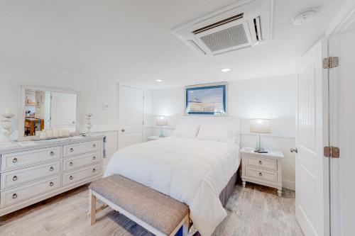 a white bedroom with a bed and a sink at Seas the Day OBX in Kitty Hawk Beach