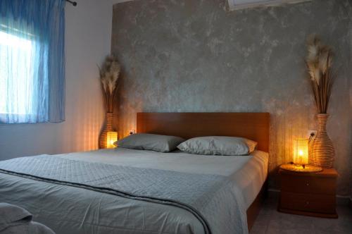 a bedroom with a bed with two lamps on it at Georgias house in Yerakiní