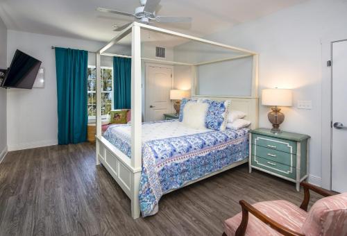 a bedroom with a canopy bed and blue curtains at Hotel Pass Christian in Pass Christian