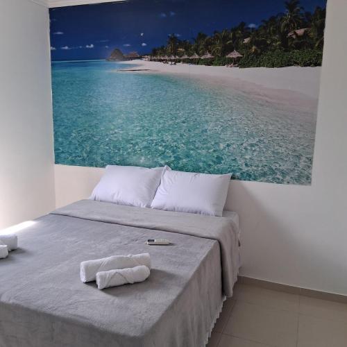 a bedroom with a bed with a picture of the ocean at Apartamento no Antares in Maceió