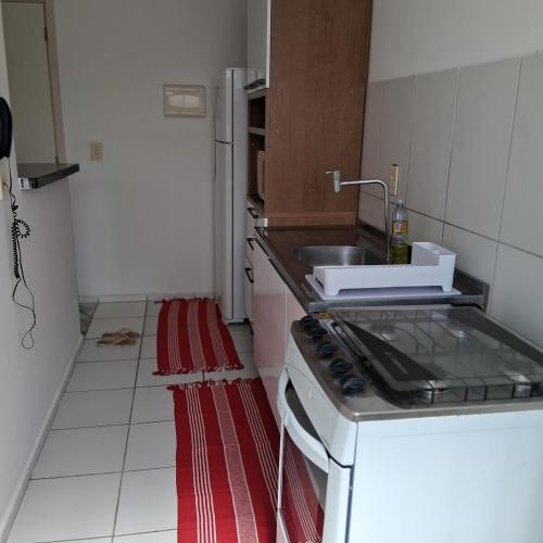 a small kitchen with a sink and a stove at Apartamento no Antares in Maceió