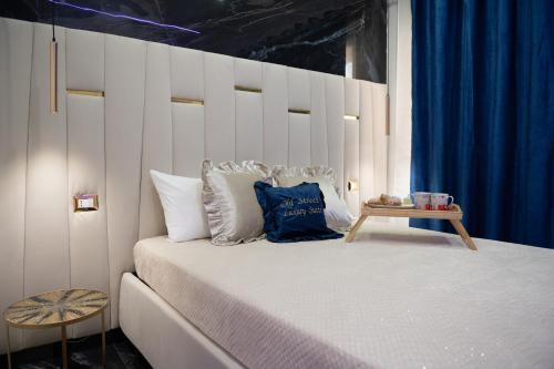 a bedroom with a large bed with a blue curtain at OLD STREET Luxury suite in Avola