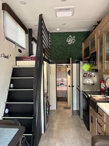 an rv kitchen with stairs and a refrigerator at Bumblebee - Luxury Destination Trailer in Canyon Lake