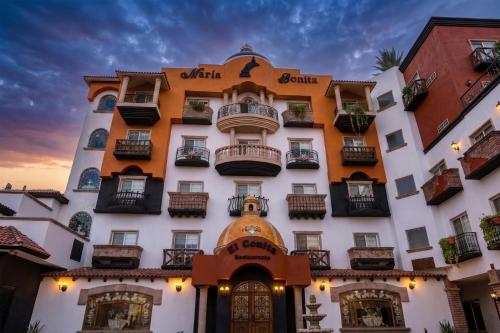 a building with balconies and a sunset in the background at Business Hotel & Suites María Bonita in Ciudad Juárez